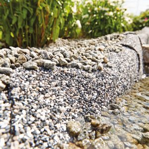 Stenfolie sand langs damkant i hagen