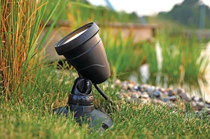 LunAqua Connect LED-spot ved damkant i gresset