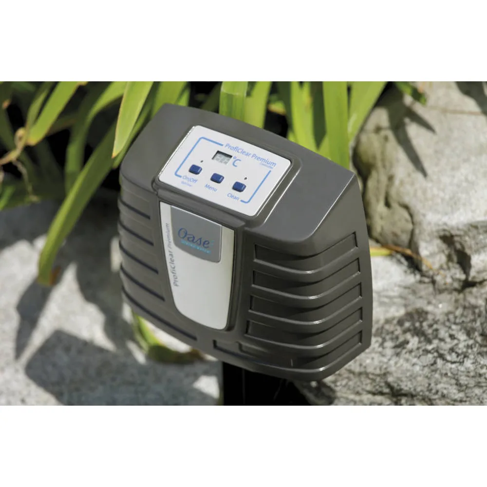 Styreenhet til OASE ProfiClear Premium med display og knapper ved steiner og planter