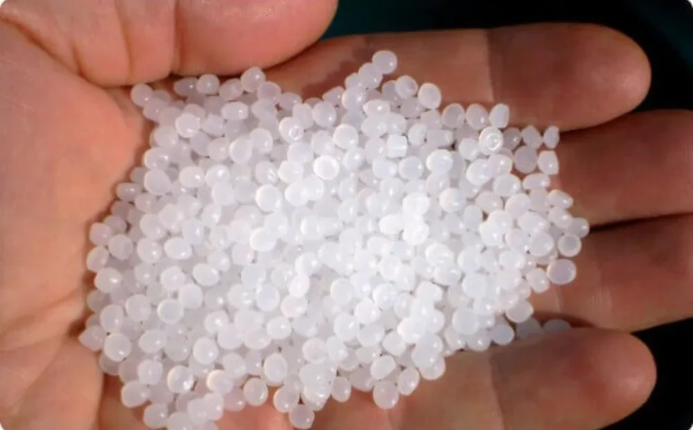 Hvite plastperler til beadfilter i en hånd, perlene der bakteriene vokser
