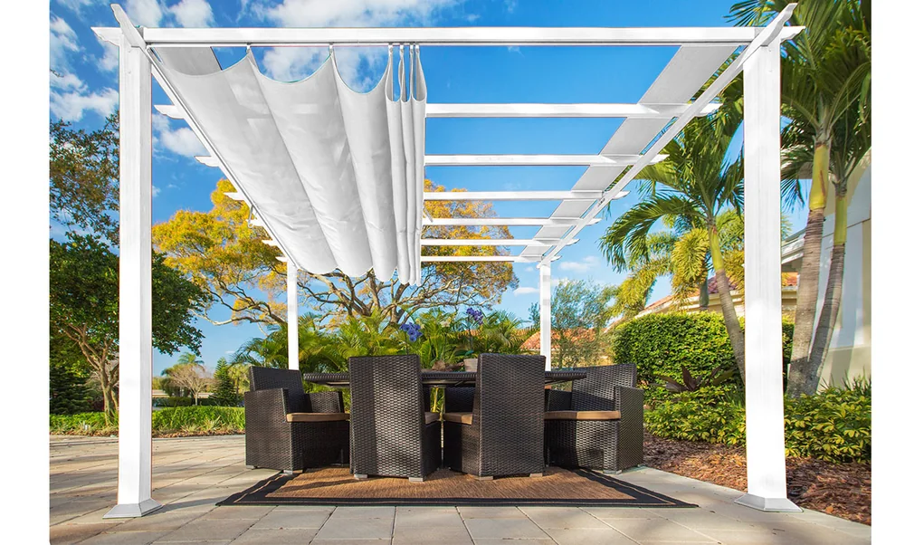 Hvit gop Florida pergola med lys takduk over spisebord og stoler på en steinlagt uteplass