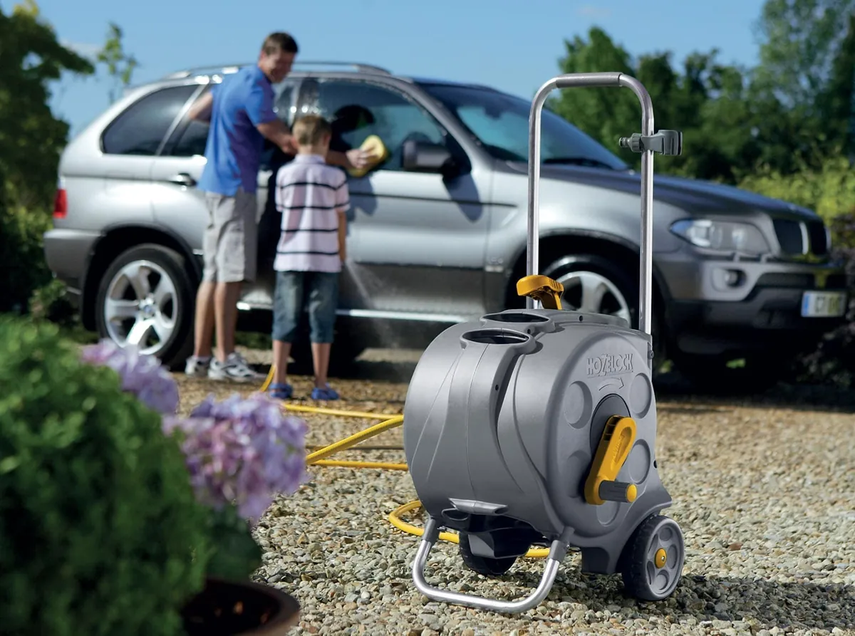 Hozelock Compact Cart slangevogn med gul slange på gruset ved bilvask