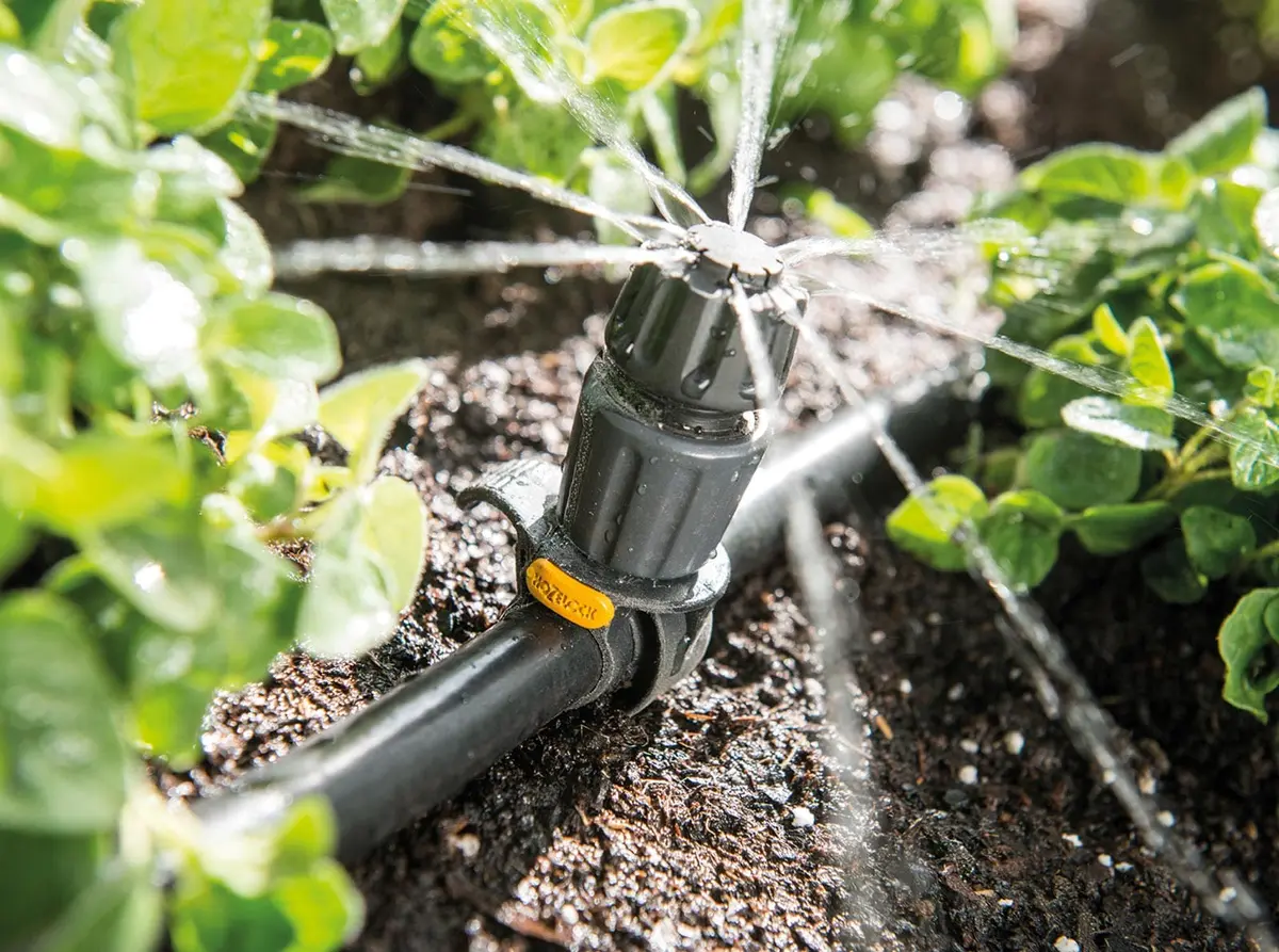 Hozelock Easy Drip Universal drypper med gul lås sprer vann over unge planter i kjøkkenhagen