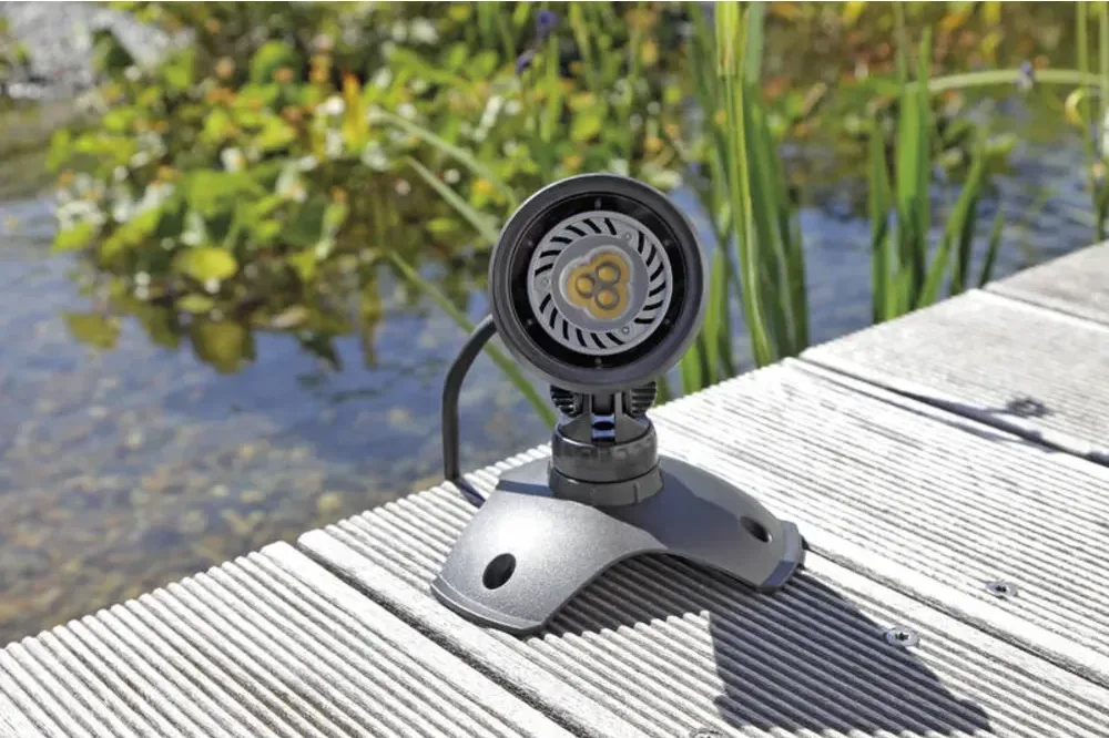OASE LunAqua 3 LED spotlys i grått på fot stående på en brygge ved vannet