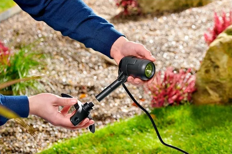 Hender setter jordspyd på en LunAqua Connect S Solo hvit-spot i et grusbed
