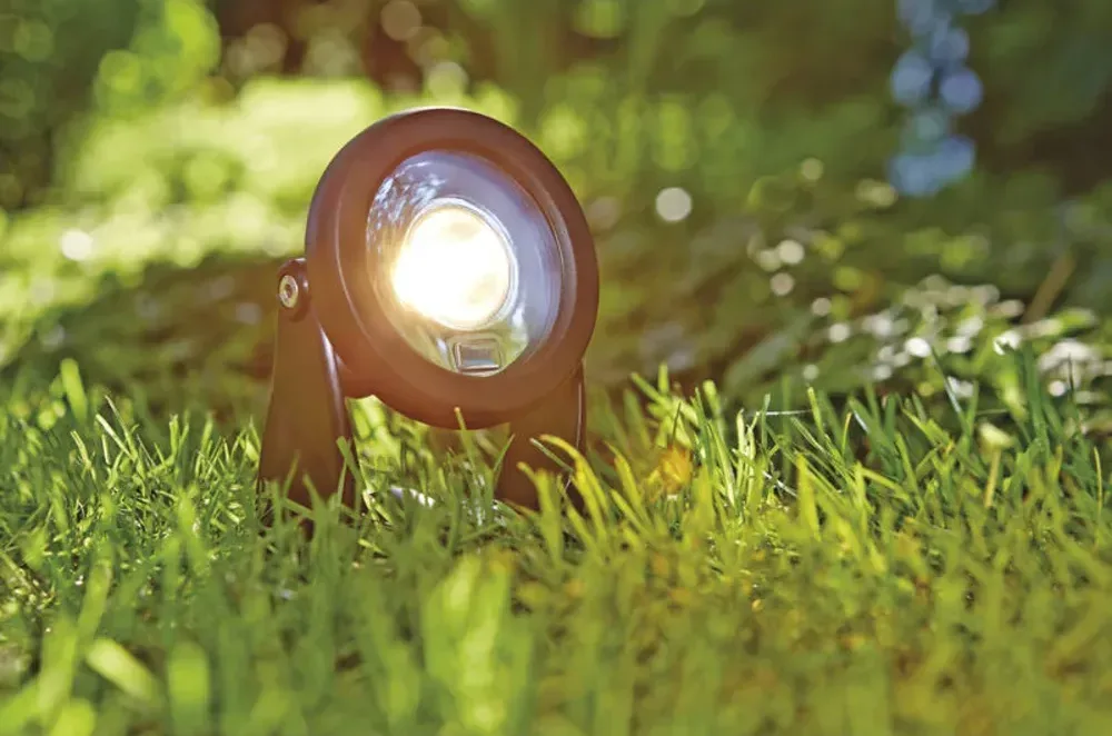 OASE LunAqua Power LED spotlys lyser varmt hvitt i gresset i hagen