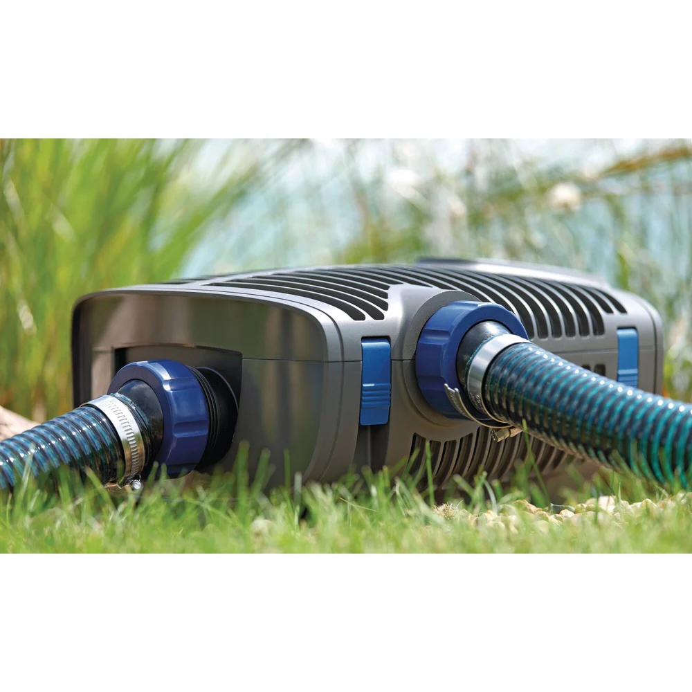OASE AquaMax Eco Premium 12 V filterpumpe med to slanger tilkoblet i gresset ved dammen
