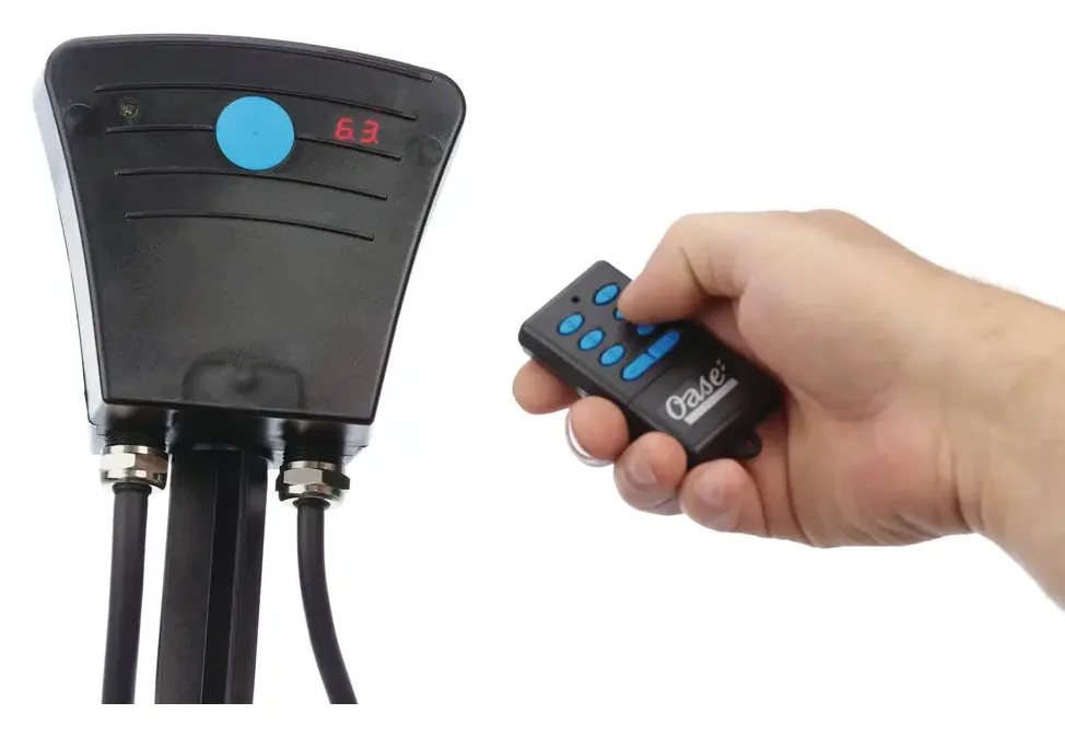 Mottaker med display og fjernkontroll i hånden til OASE AquaMax Eco Twin