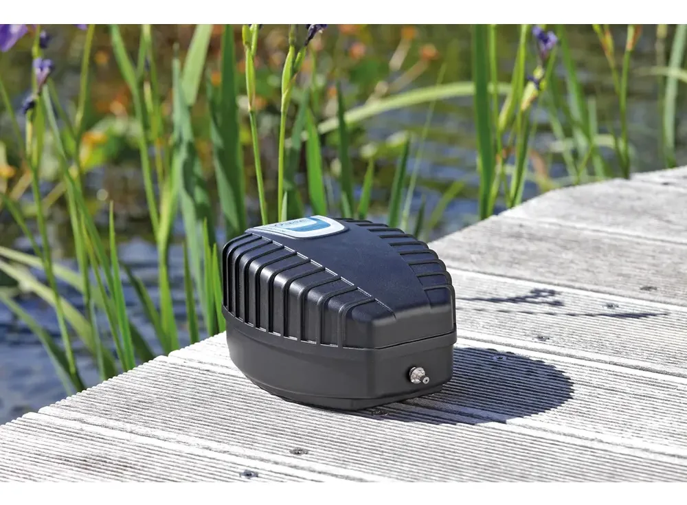 OASE AquaOxy 500 luftpumpe står på en terrasse av tre ved dammen