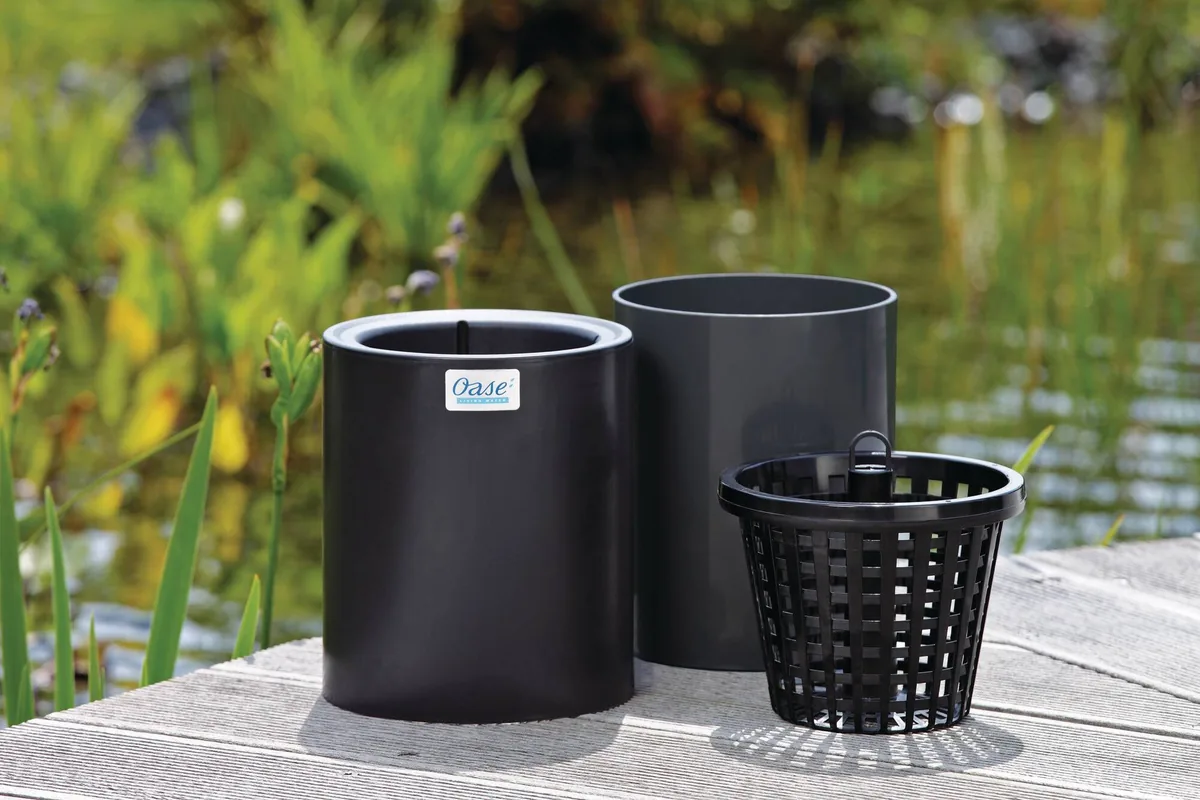 OASE AquaSkim Gravity med flyteelement, hus og kurv på en terrasse ved dammen