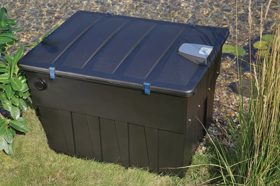 BioTec ScreenMatic² 60000 med lokket på, ved dammen blant gress og planter