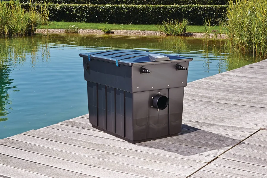 BioTec ScreenMatic² 90000 på en terrasse av tre ved kanten av dammen