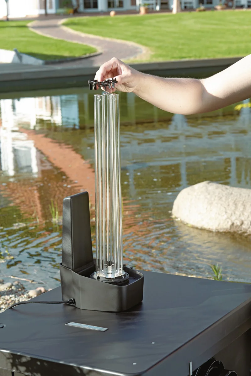 Kvartsglasset løftes ut av OASE Bitron Eco 180W ved hagedammen