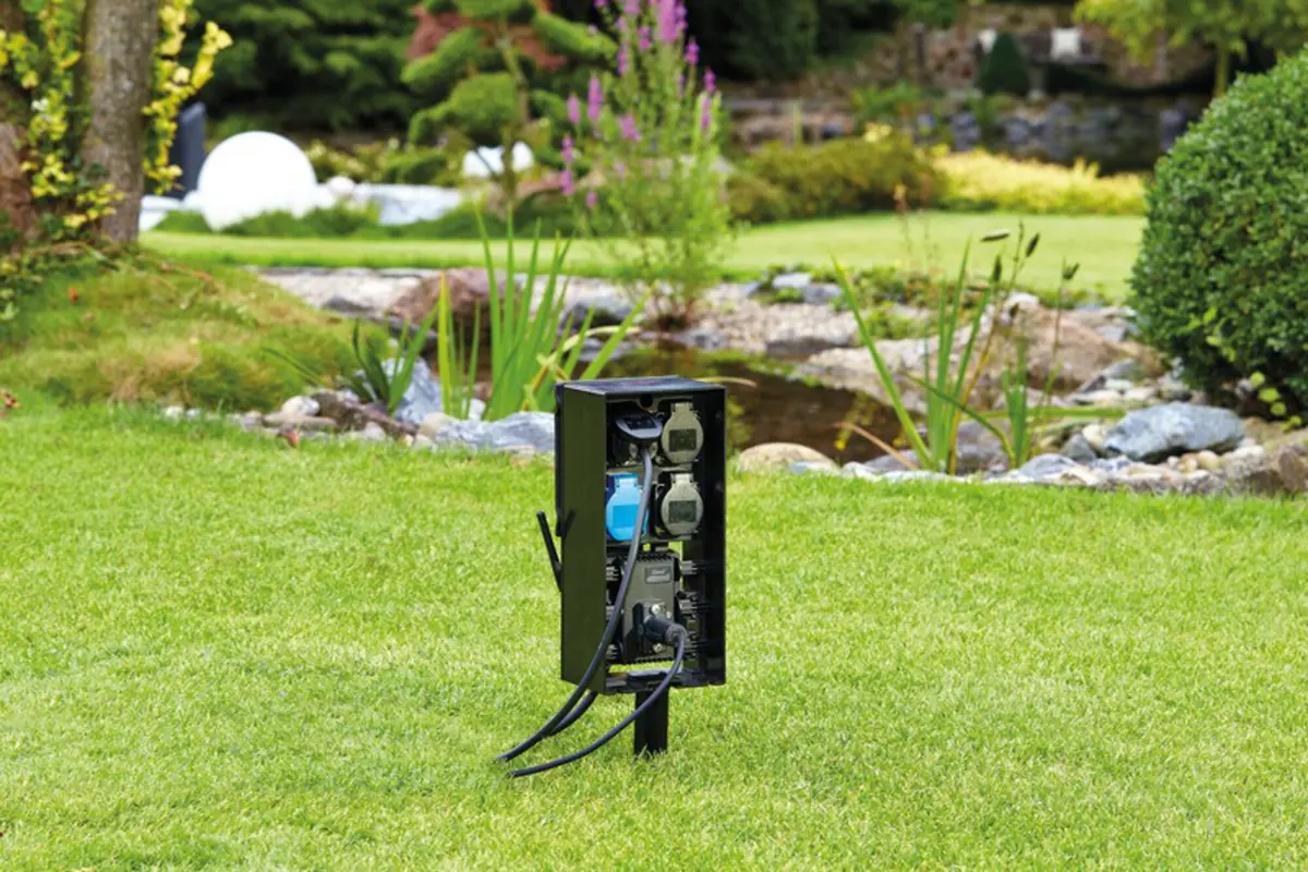 OASE FM Master WLAN el-skap med antenne på jordspyd i plenen ved hagedammen