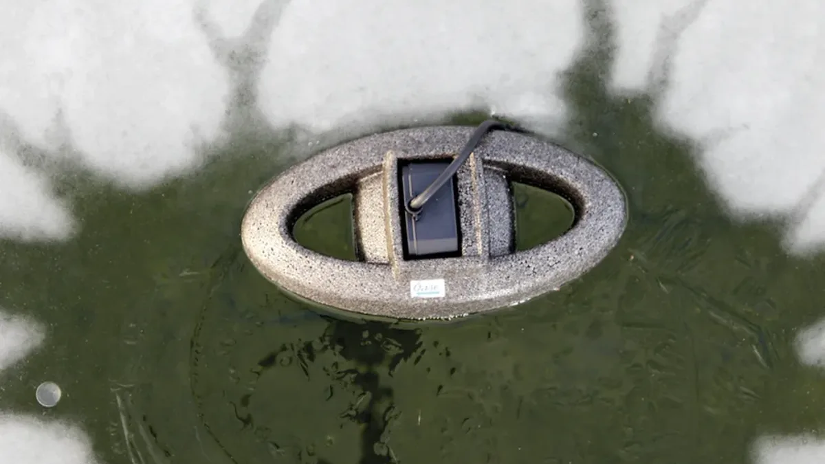 OASE IceFree Thermo 330 flyter i et åpent hull i isen og holder hagedammen isfri om vinteren