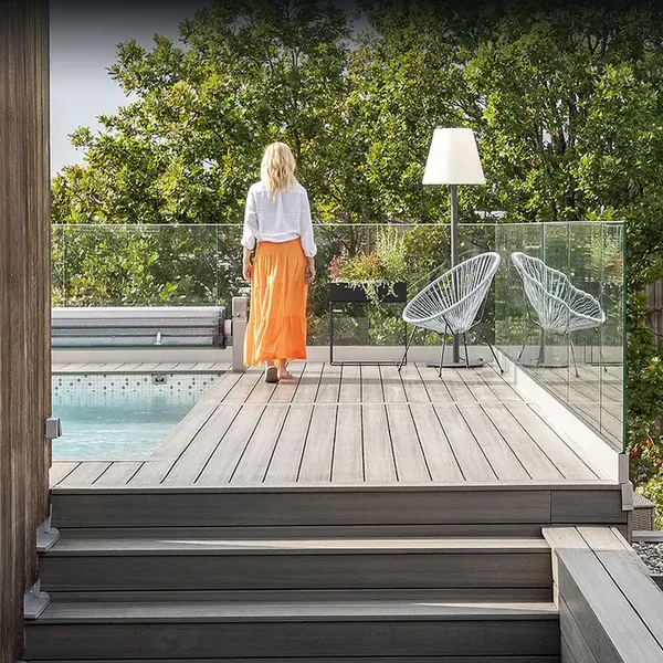 Lys grå terrasse i trekompositt med trapp ned mot hagen