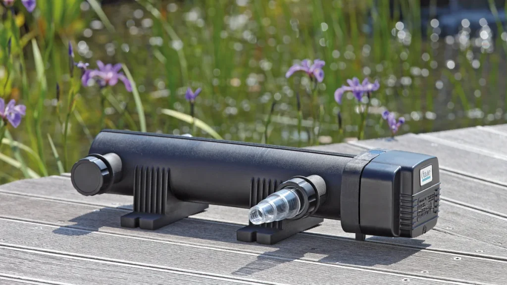 OASE Vitronic UV-filter på terrassen ved hagedammen med iris og siv i bakgrunnen